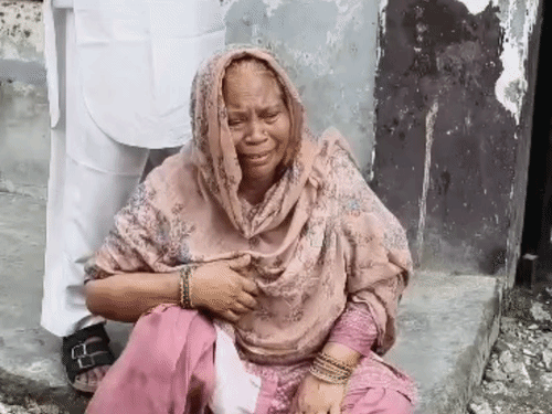 प्रशासन की कार्रवाई की विरोध करते हुए रोती मकान में रह रही महिला।