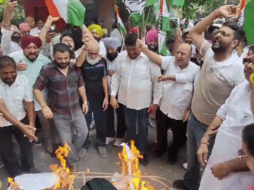 नारेबाजी करते हुए पुतले फूंकते कांग्रेस कार्यकर्ता।