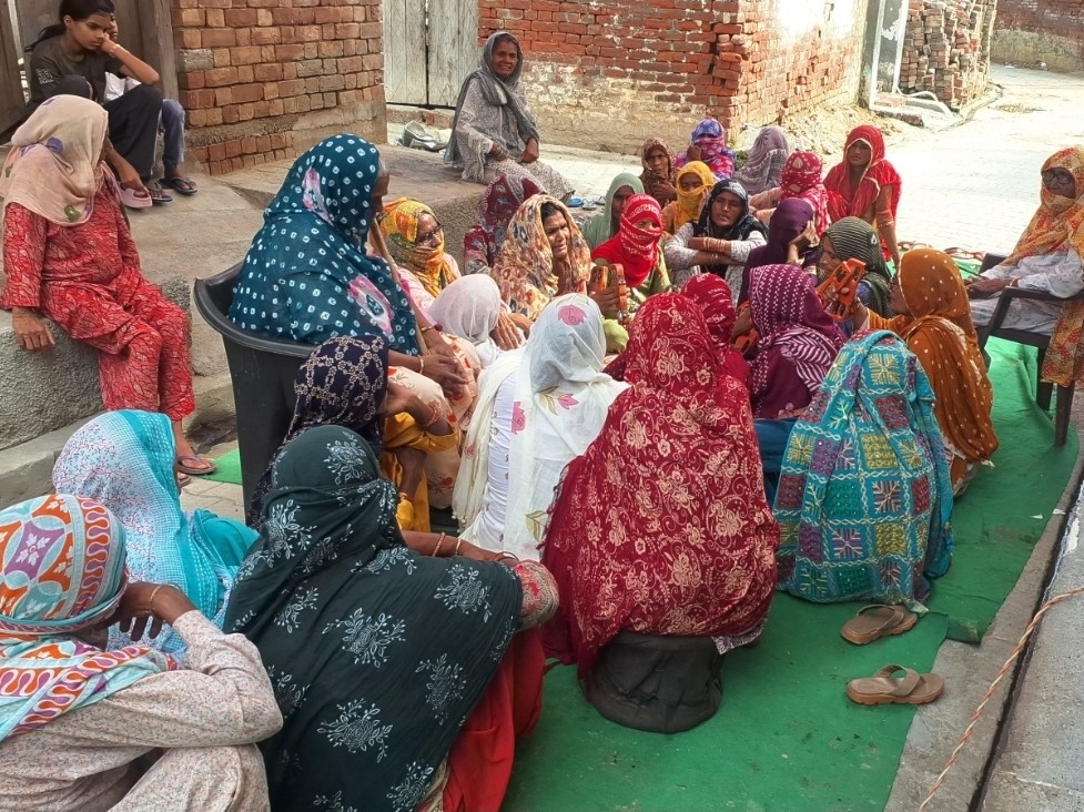 गांव में बैठी महिलाएं आपस में चर्चा करते हुए।