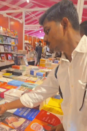 पुस्तक महोत्सव में स्टॉल पर किताबें देखते छात्र।