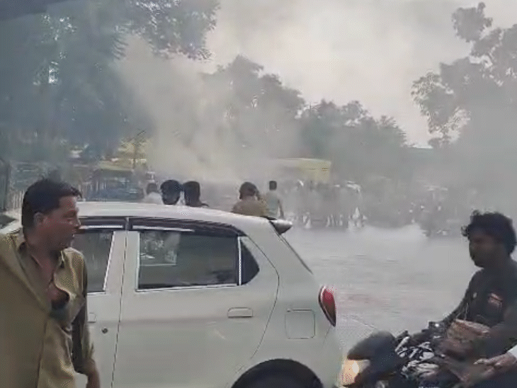 कार में आग लगने के बाद चालक उसी में फंस गया, जिसे ट्रैफिक पुलिस के जवानों ने बाहर निकाला।