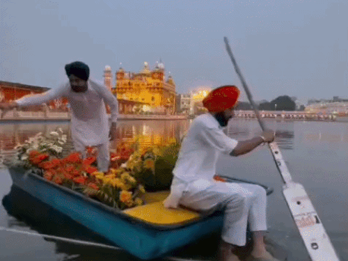 फूलों को ले जाते हुए सिख श्रद्धालु।