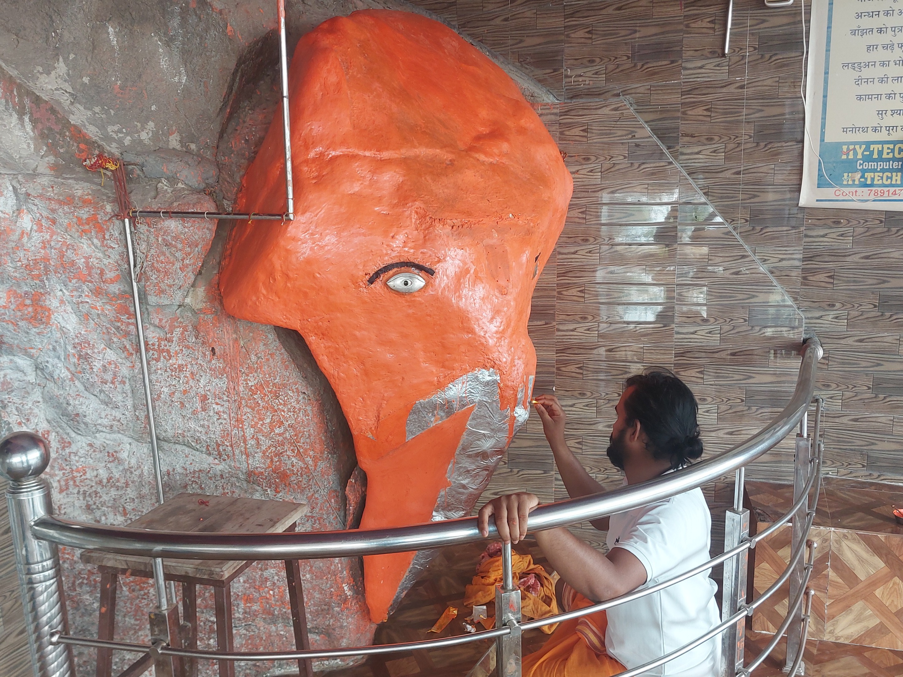 पहाड़ी की चट्टान पर उभरी भगवान गणेश की प्रतिमा का पुजारी ने श्रृंगार किया।