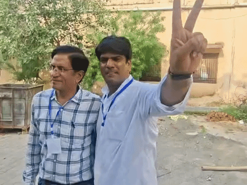 जीत के बाद प्रत्याशी के एजेंट विक्ट्री साइन दिखाते हुए।