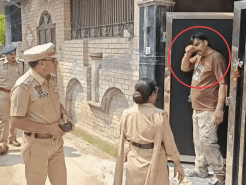 पुलिस के सामने आंखे मलते हुए घर से बाहर निकलता आरोपी। - Dainik Bhaskar