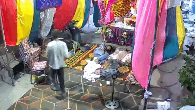 पंडाल में पड़े पंखे पर तार लपेटते हुए।