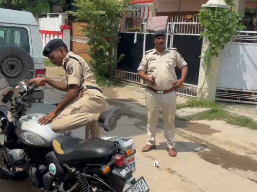 छापेमारी के दौरान घर के बाहर खड़े पुलिसकर्मी।
