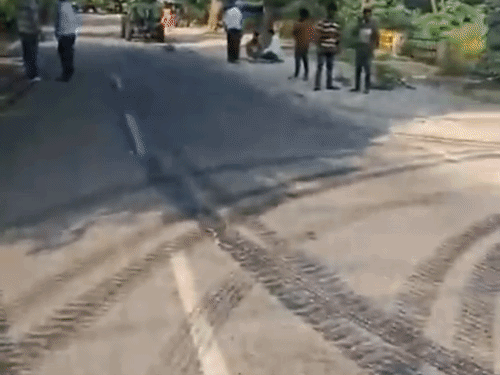 सड़क पर कारपेटिंग करते हुए वर्कर्स।