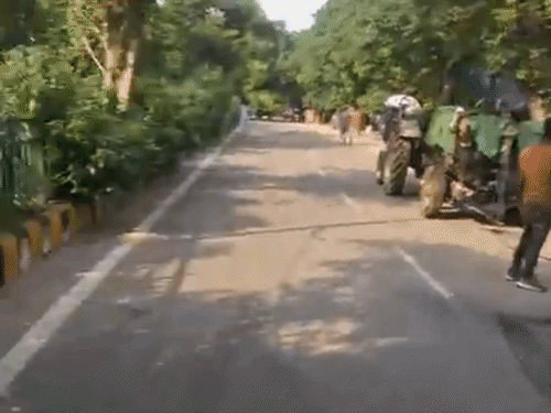 बिल्कुल साफ-सुथरी सड़क पर कारपेटिंग करती मशीनरी।