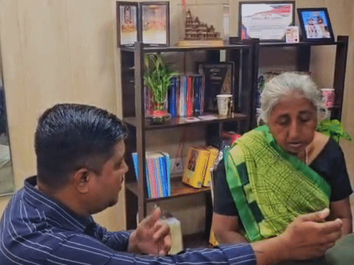 गुजरात से 2017 में लापता हुईं रतन बेन (55) नौ साल बाद लखनऊ में मिलीं। बेटा उनको फैमली फोटो दिखाते हुए।