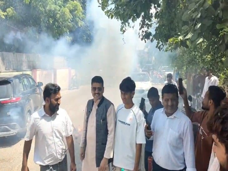 मयंक गोयल के नामांकन दाखिल करने के बाद बाहर आतिशबाजी करते हुए कार्यकर्ता।