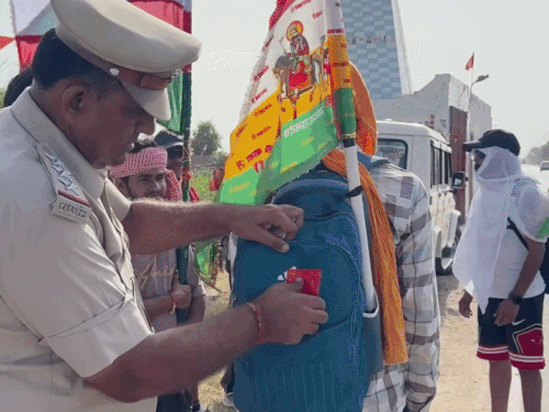 हनुमानगढ़ में तीर्थयात्रियों के बैग पर रिफ्लैक्टर लगाते ट्रैफिक इंचार्ज अनिल चिंदा।
