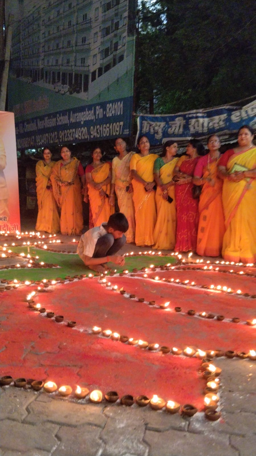 दीप जलाती महिला कार्यकर्ता।