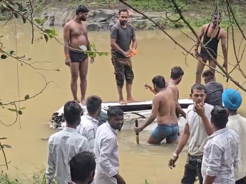 कार के अंदर से शवों को निकालते दिख रहे स्थानीय लोग।