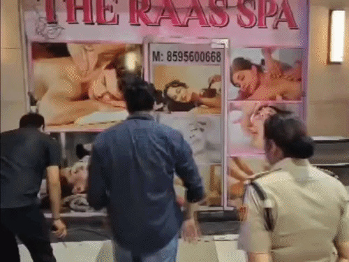 अंदर से बंद किए गए स्पा सेंटर को खुलवाते हुए पुलिस।