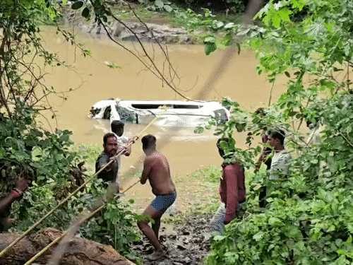 स्थानीय लोगों की मदद से कार को बाहर निकाला जा रहा।