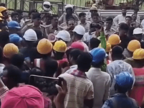 हंगामा कर रहे मजदूरों को समझाती पुलिस।