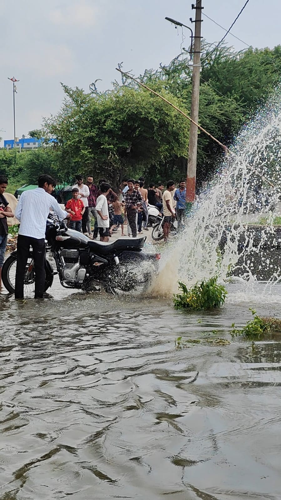 घाट पर बाइक से स्टंट करते हुए युवा।