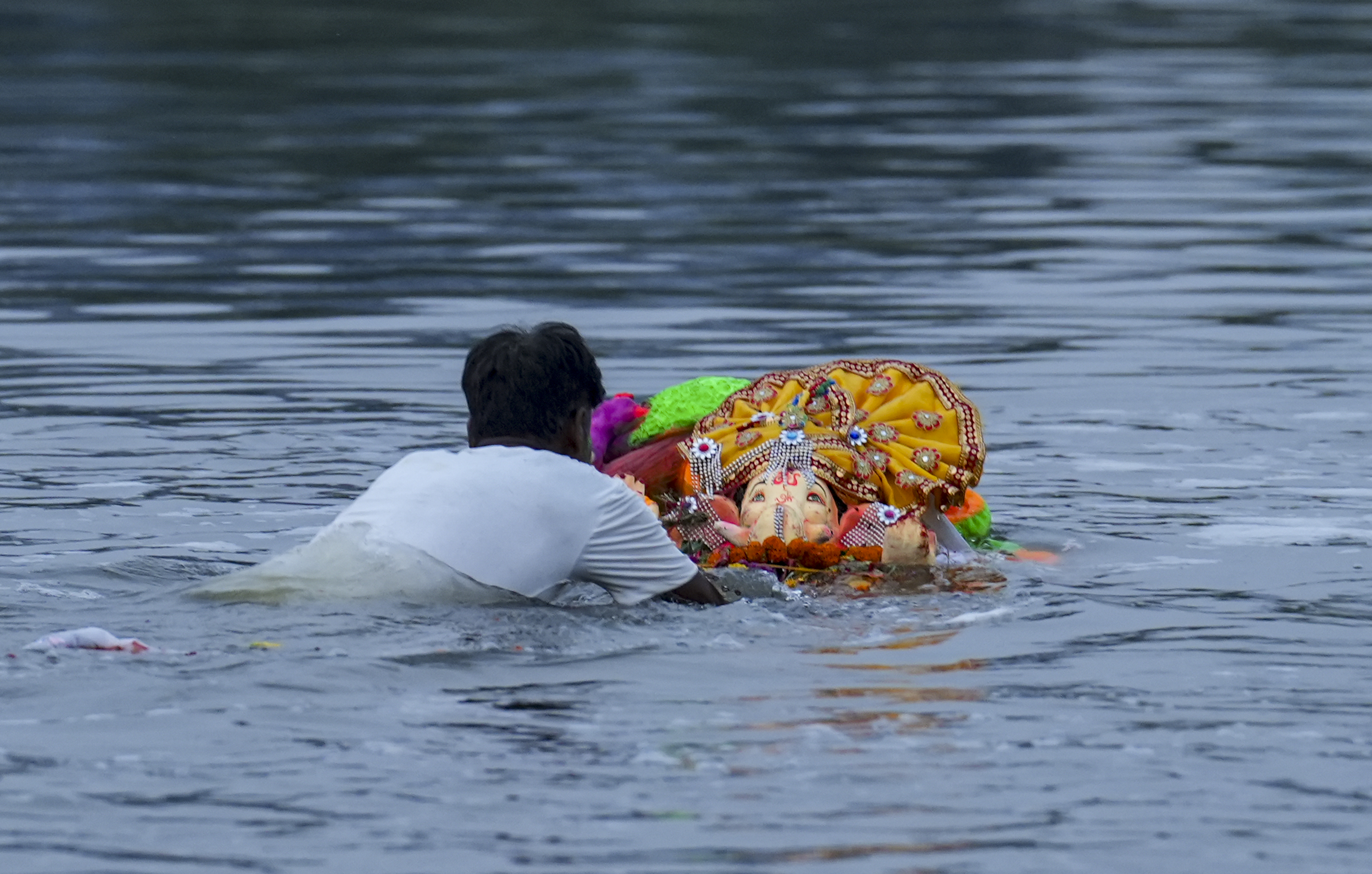 नई दिल्ली में 'गणपति विसर्जन' के दौरान कालिंदी कुंज घाट पर भगवान गणेश की मूर्ति का विसर्जन किया जा रहा है।