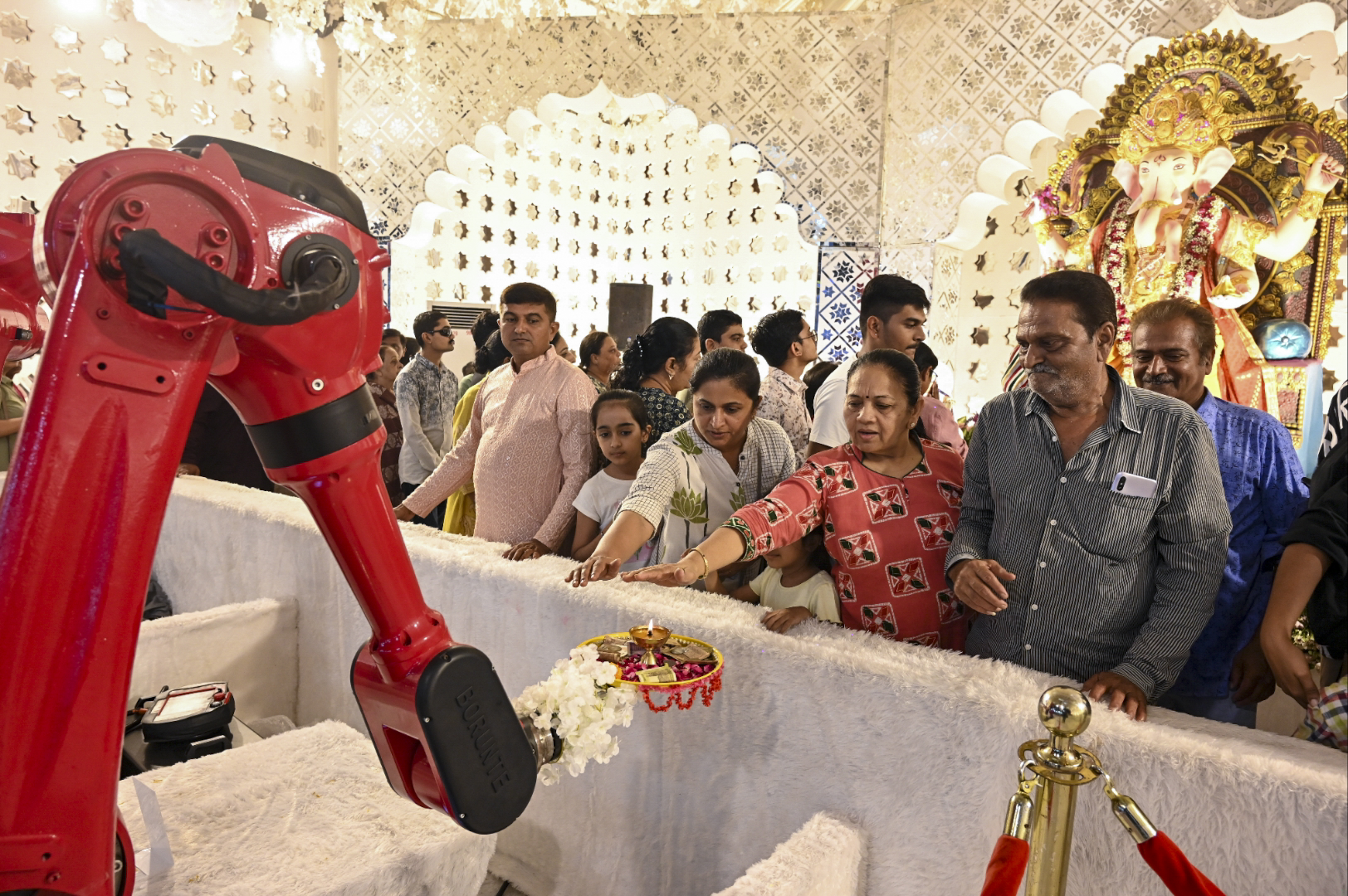 गुजरात के राजकोट में एक सेंसर-बेस्ड रोबोट भगवान गणेश की मूर्ति के सामने 'आरती' कर रहा है।