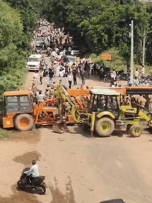 प्रदर्शनकारियों को रोकने के लिए पुलिस ने बीच सड़क पर जेसीबी खड़ी कर दी है।