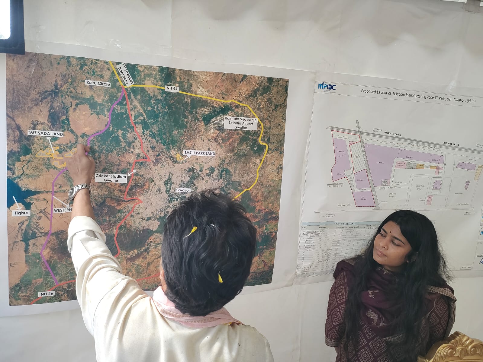 टेलीकॉम मैन्युफैक्चरिंग जॉन के मैप को देखकर महिला अधिकारी से जानकारी लेते हुए सिंधिया।