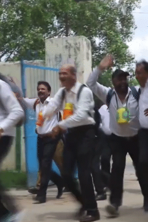 बुजुर्ग दोस्त सफेद कमीज, काली पैंट और गले में पानी की बोतलें लटकाए स्कूल पहुंचे।