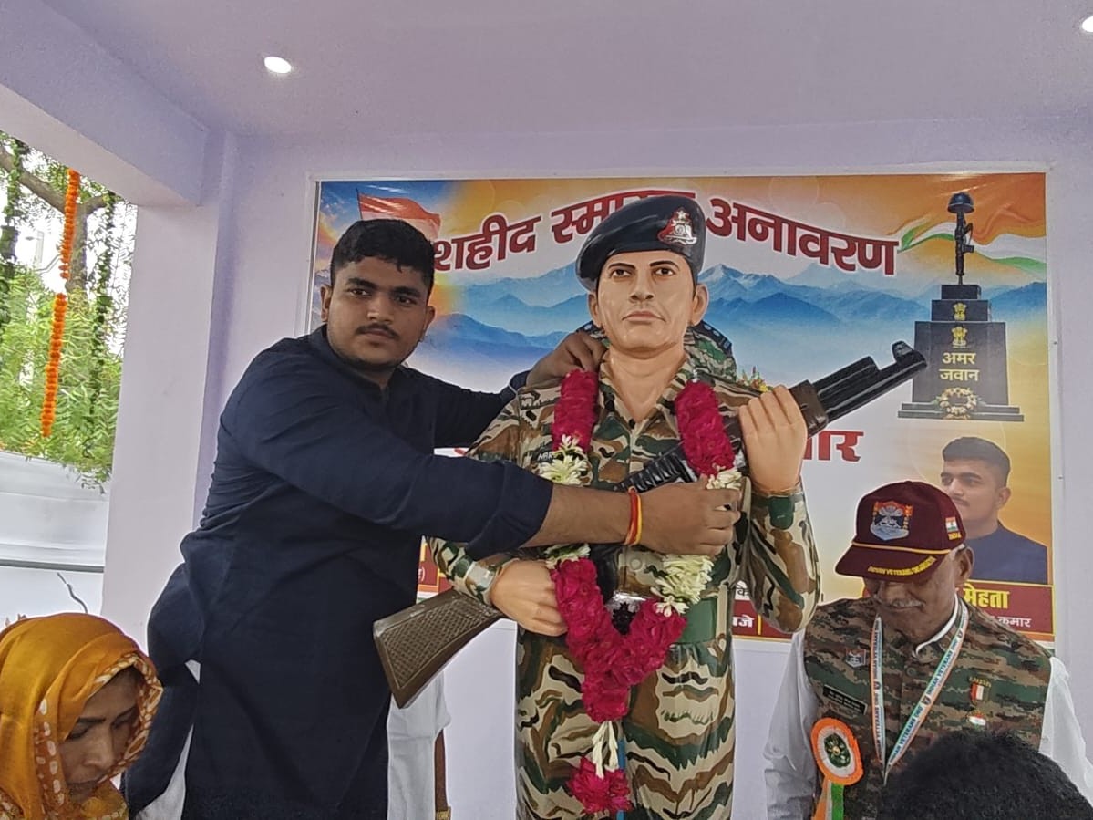 शहीद सुबेदार नरेश कुमार का लड़का आकाश मेहता अपने पिता की प्रतिमा को माला पहनाते हुए।