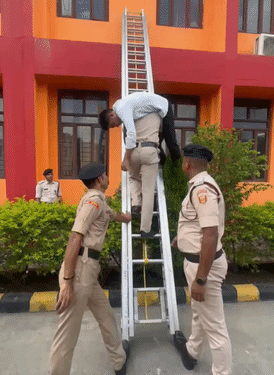 मॉक ड्रिल के दौरान सीढ़ी से एक शख्स को उतारता फायर फाइटर।