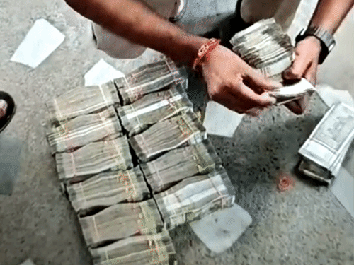 बरामद कैश को गिनते हुए पुलिस कर्मी।