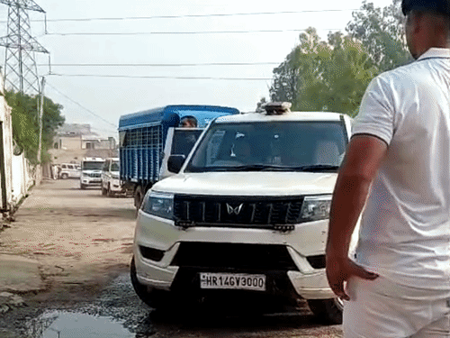 Gangster Manpal Dhilla arrives at the farmhouse under tight police security.