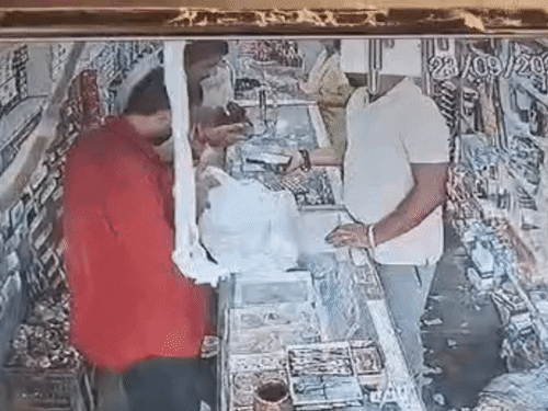 दुकानदार बबलू के मोबाइल यूपीआई स्केनर से पेमेंट करने का नाटक करता युवक। - Dainik Bhaskar