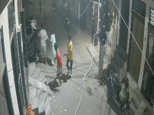 बदमाश हाथ में हथियार लेकर हमला करते दिख रहे हैं, महिला उनको रोकती है।