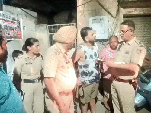 लोगों से पूछताछ करती हुई पुलिस।