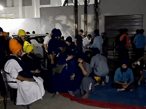 थाने के बाहर बैठकर नाम जप और सिमरन करते निहंग।