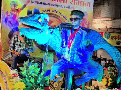 श्री महावर कोली समाज की झांकी में ड्रेगन, पपेट लेकर युवक।