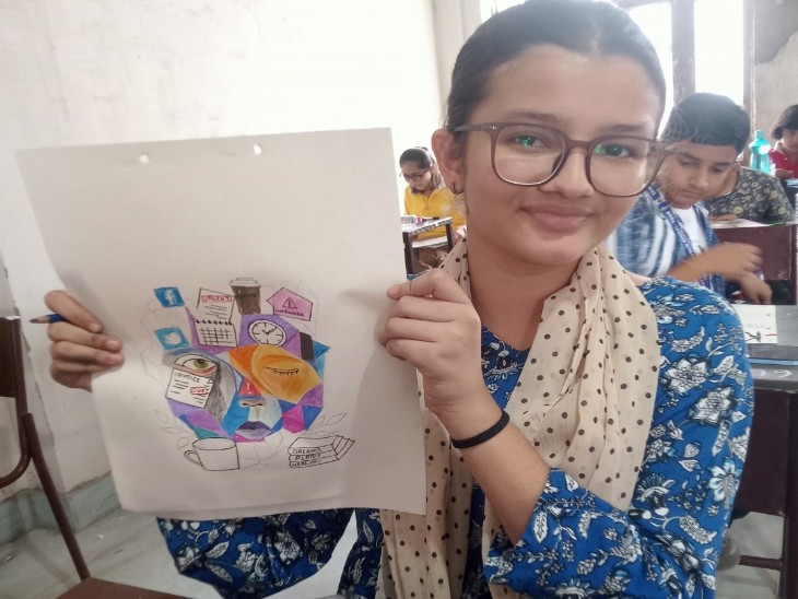 बाल चित्रकला प्रतियोगिता में अपनी चित्रकारी दिखाती छात्रा।