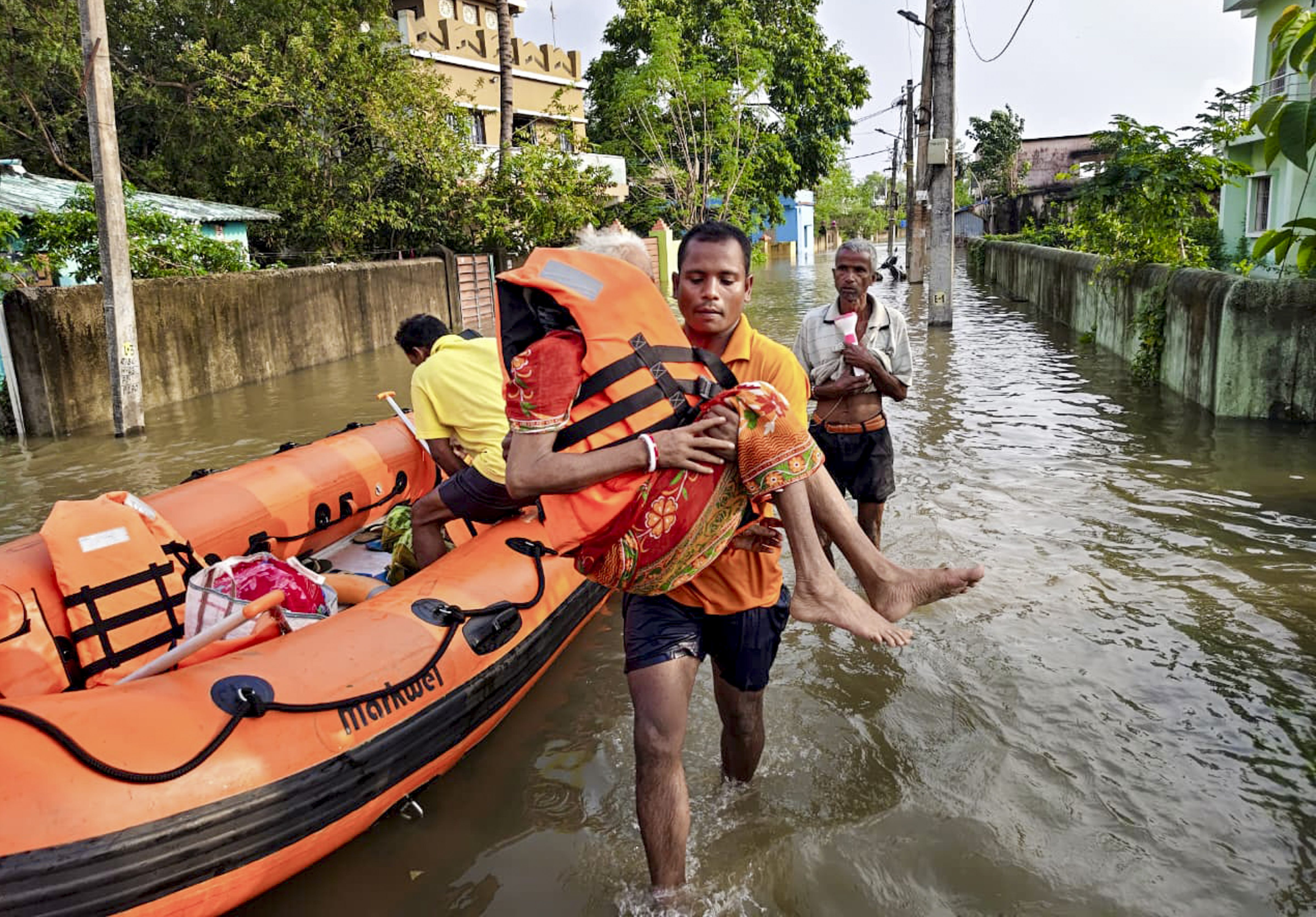 ओडिशा के बालेश्वर के सहदेवखुंटा में भारी बारिश के बाद एक अधिकारी ने बाढ़ से प्रभावित लोगों को सुरक्षित जगह पर पहुंचाया।