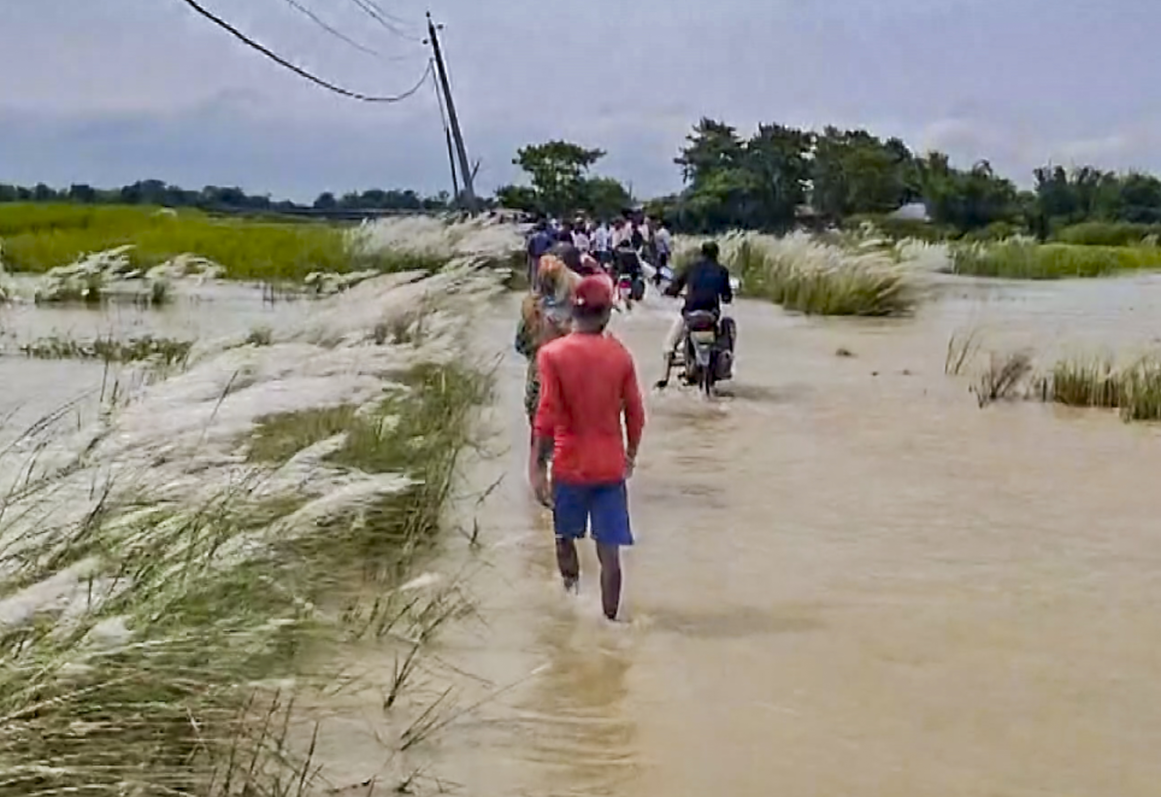 बिहार के सुपौल जिले में कोसी नदी का जलस्तर बढ़ने से बाढ़ आ गई है। लोग पानी से भरे इलाके से गुजरते हुए नजर आ रहे हैं।