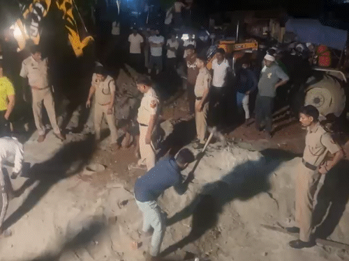 बोरवेल के पास से मिट्टी हतवाते पुलिसकर्मी।