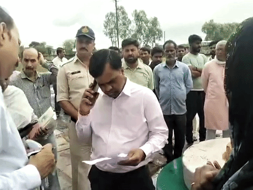 तहसीलदार को फोन लगाकर बात करते कलेक्टर।