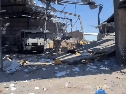 Photo of a storage building after the attack. The roof of the building is broken from the front.
