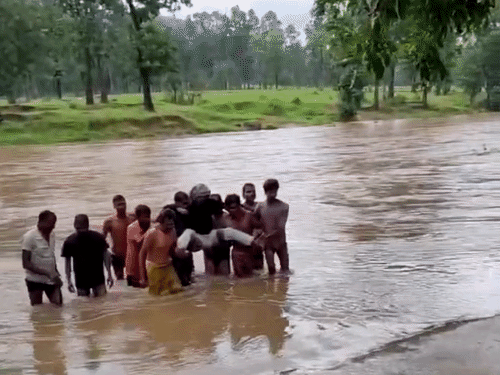 छत्तीसगढ़ में कोरबा जिले के मैनगढ़ी में एक बीमार शख्स को उठाकर नदी पार कराते गांव वाले।