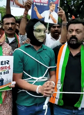 राजकोट में कांग्रेस कार्यकर्ताओं ने मुख्य चुनाव आयुक्त ज्ञानेश कुमार का मुखौटा पहनाकर युवक को रस्सी से बांध दिया और कलेक्टर कार्यालय ले जाया गया।