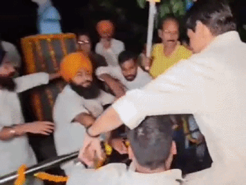 कंधो पर उठाकर जलभराव के बीच शहीद ए आजम भगत सिंह की प्रतीमा की तरफ लेकर जाते एनएसयूआई के सदस्य।