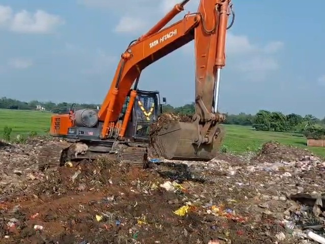 JCB से कचरा हटाया जा रहा है।