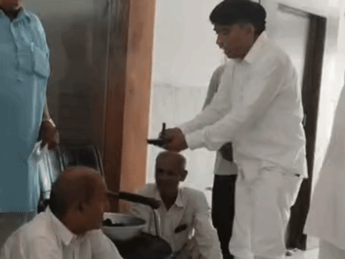 सड़क से उखाड़कर लाए गए घटिया मटेरियल वाले टुकड़ों को थाली में रखकर प्रतीकात्मक कुर्सी की आरती उतारते ग्रामीण। - Dainik Bhaskar