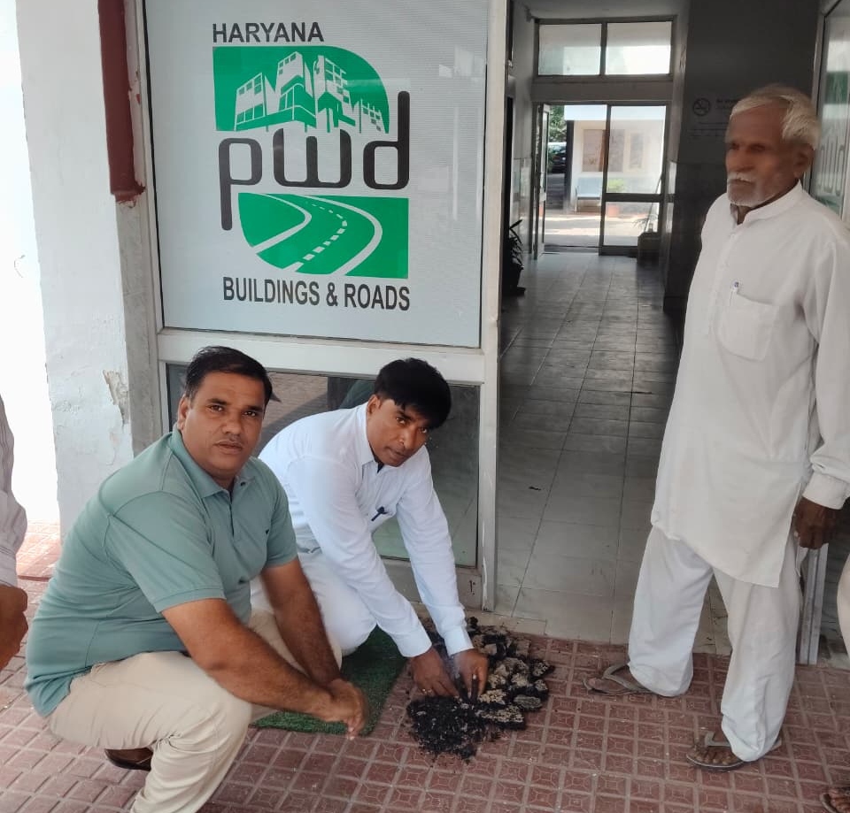 सड़क से उखाड़कर लाए गए घटिया मटेरियल वाले टुकड़ों को कार्यालय के सामने रखते ग्रामीण।