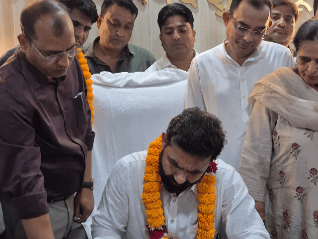 नगर परिषद आयुक्त सभापति से कागजी कार्रवाई पूरी करवाते हुए।