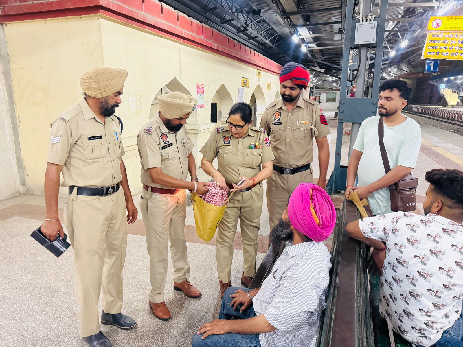 यात्रियों के सामानों की जांच करते पुलिस अधिकारी